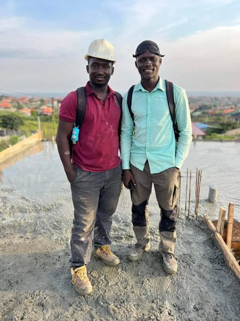 Deux professionnels debout sur la dalle d’un bâtiment en construction.